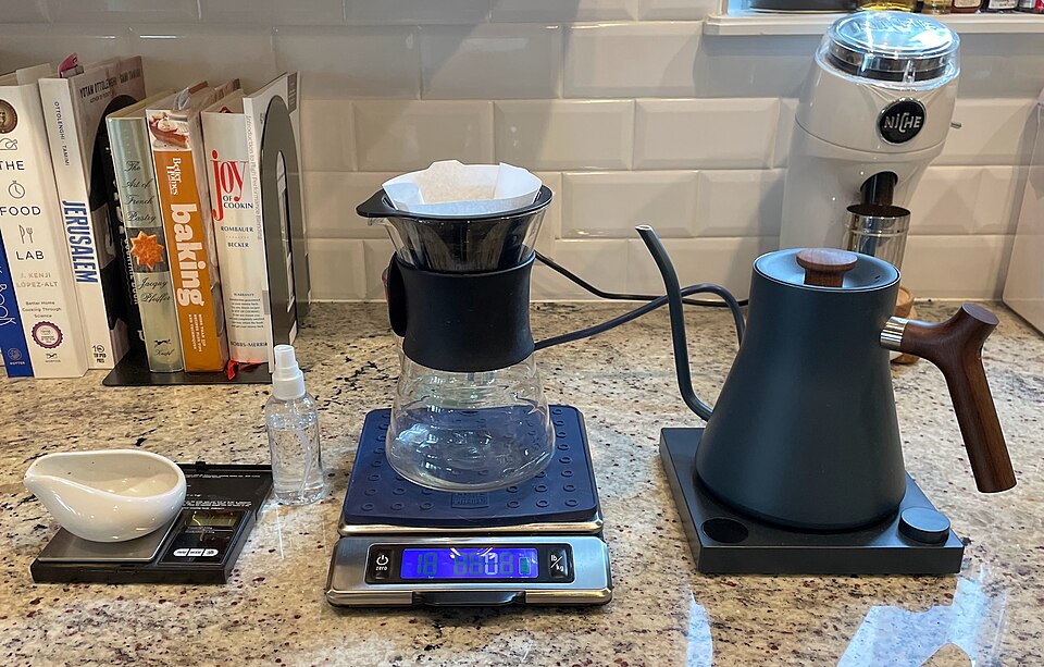 一只鹅颈手冲壶正将热水注入滤杯